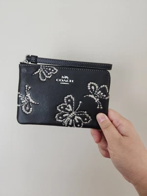 Muñequera Coach Corner con cremallera con estampado de mariposa brillante CCJ72 Foto 1 de 4