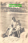 R360807 Woman With Light Colour Clothes Sitting On The Rock With Her Two Childre