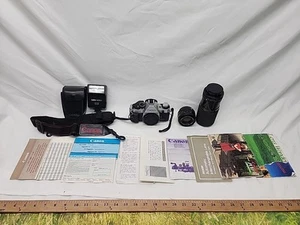 Canon Silber AE-1 35mm Spiegelreflexkamera mit 2 Objektiven, Tasche, Blitz, Prospekte, Trageriemen - Bild 1 von 10
