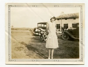 Foto encontrada de telón de fondo de una mujer joven de la década de 1920 de autos vintage y misterio de dos ruedas - Imagen 1 de 2