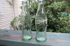 2 green glass Coca Cola,Coke bottles,hobbleskirt,1 applied white color,1 clear