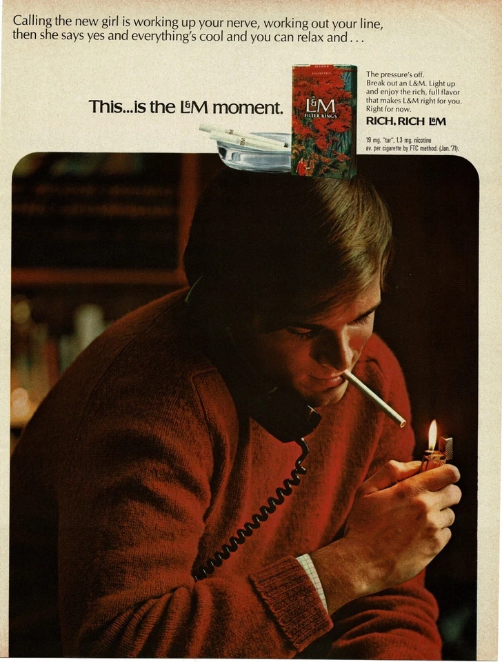 1971 L&M Cigarettes hombre con suéter rojo iluminando uno anuncio impreso vintage Foto 1 de 1