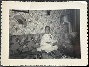 Schnappschussfoto ~ Mann auf gemusterter Couch trägt chinesischen Seidenpyjama - schwules Interesse - Bild 1 von 3