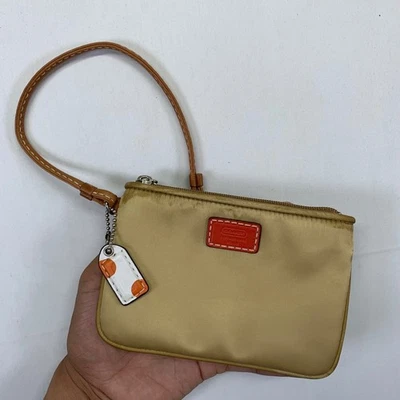 Carteira Coach Leatherware bronzeada pulseira bolsa pequena acabamento laranja berloque bolinhas - Imagem 1 de 4