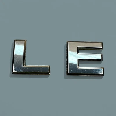 Nissan LE emblema letras insignia calcomanía logotipo Armada Titan Frontier trasero OEM genuino Foto 1 de 4