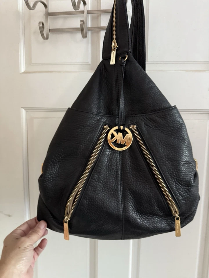 Mochila Michael Kors de cuero negra con herrajes dorados Foto 1 de 4