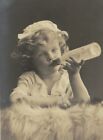PA1473 LITTLE VICTORIAN TODDLER FEEDING HERSELF WITH A BOTTLE 1908 RPPC 