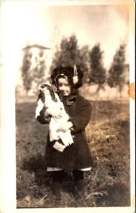 Vintage RPPC Postcard -Little girl in winter coat & bonnet holding doll - Picture 1 of 2