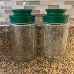 Juego de 2 frascos de vidrio vintage Anchor Hocking Tang tapas de plástico verde primavera invierno - Imagen 1 de 2