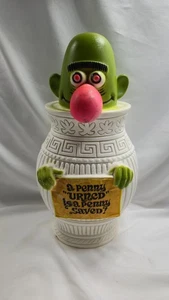 Banco de monedas de plástico vintage divertido personaje urna un centavo urna cara verde nariz rosa - Imagen 1 de 2