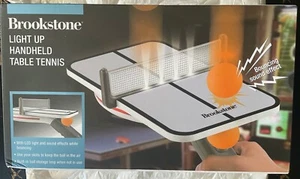 Neu Brookstone beleuchtetes Handheld-Tischtennisspiel mit Licht & Sound NEU - Bild 1 von 3