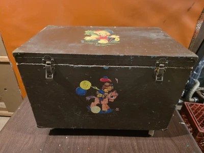 cofre de juguete de madera vintage, marrón oscuro con personajes pintados, tapa con bisagras, ruedas Foto 1 de 4