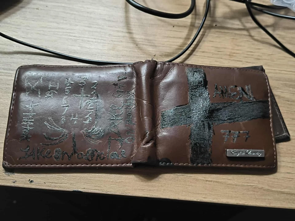 Cartera de cuero tatuada diseñada a medida con cierta edad visible y uso Foto 1 de 1