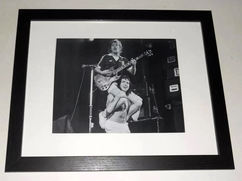 Framed AC/DC Bon Scott, Angus Young on shoulders, 1979 On Stage  13" by 16" - Image 1 of 2
