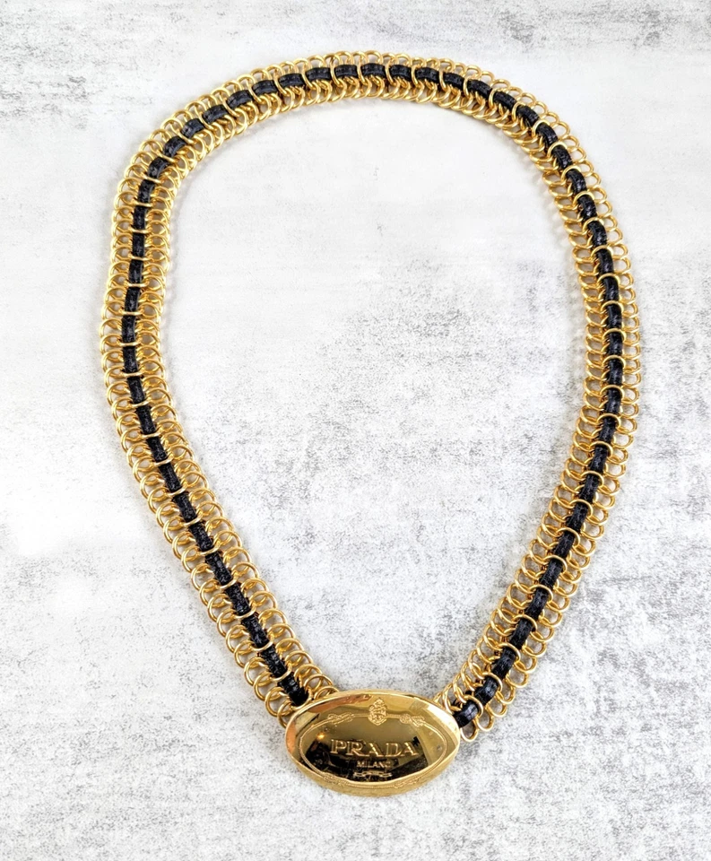 Cinturón de cadena dorada vintage PRADA, cuero negro entretejido, hebilla con logotipo en tono dorado Foto 1 de 4