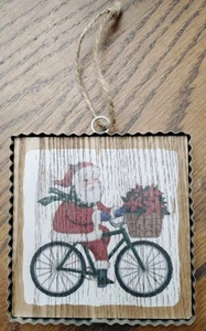 Babbo Natale in bicicletta ornamento natalizio in legno 4" fiori quadrati in cesto sul davanti - Foto 1 di 3