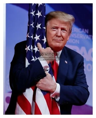 PRESIDENT DONALD TRUMP HUGGING AMERICAN FLAG 8X10 PHOTO - Image 1 of 4