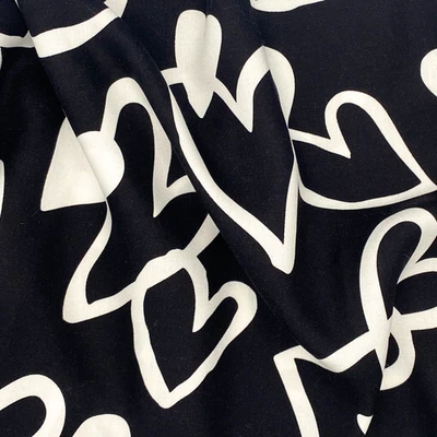 Caprichosa tela con estampado de rayón corazón blanco y negro por yarda -58" de ancho sin existencias Foto 1 de 4