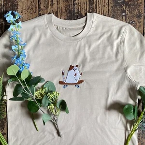 Skateboard Katze Mittelfinger besticktes T-Shirt in Sand. Unisex - Bild 1 von 3