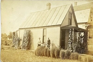 Foto real vintage de pareja de pie en patio junto a la casa - Imagen 1 de 2