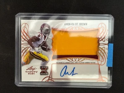 Amon-Ra St. Brown 2021 Leaf Trinity  Rookie Patch Auto( Player-Worn ) - Image 1 of 2