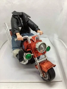Weihnachtsmotiv Actionfigur Spielzeug auf rotem Motorrad mit grünen Lichtern - Bild 1 von 10