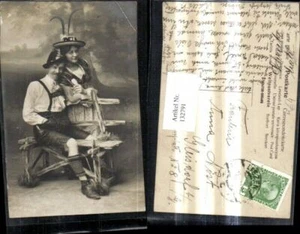 132791,Tracht Paar Liebespaar Dirndl Lederhose Federhut Hut b. Bank  - Picture 1 of 1