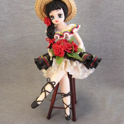 Boneca artesanal camponesa colombiana sentada em cadeira de madeira - Imagem 1 de 4