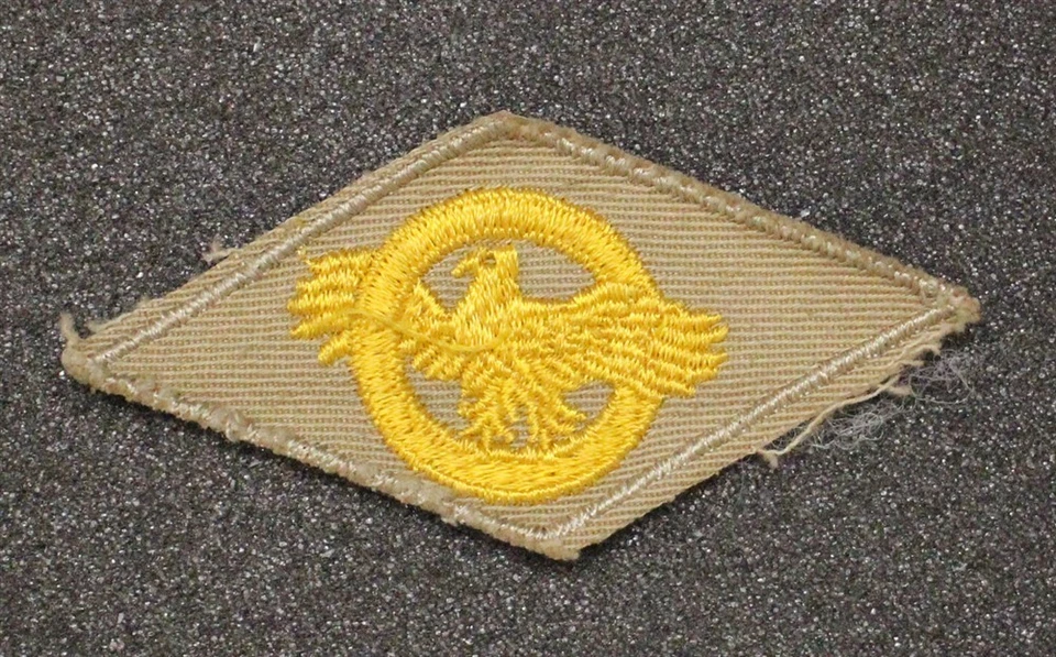 Cloth Military Badge: WWII Discharge Diamond, Ruptured Duck - on khaki - Image 1 of 1