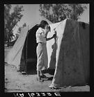 Woman in a California pea pickers' camp,mending the tent,CA,March 1937,FSA