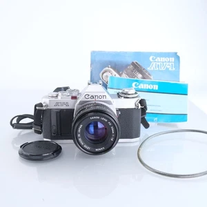 Canon AV-1 fotocamera reflex pellicola 35 mm + kit obiettivo 50 mm messa a fuoco manuale vintage AE-1 AV1 - Foto 1 di 10