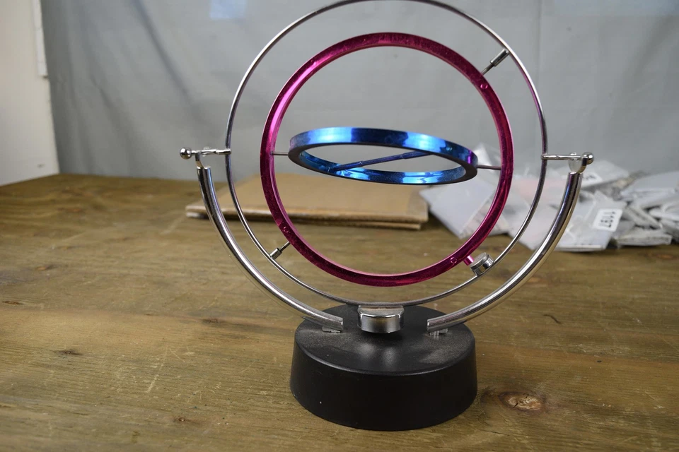 Juguete de escritorio órbita cinética movimiento perpetuo anillos giratorios alimentados por batería escultura Foto 1 de 4