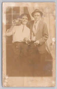 RPPC Dos hombres en sombreros con cigarro y botella Anderson Studio Lincoln NE postal - Imagen 1 de 2