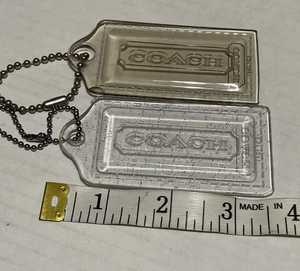 Juego de 2 LLAVEROS GRANDES GRIS HUMO COACH AMAPOLA Y PLATA TRANSPARENTE BRILLANTE ETIQUETA COLGANTE - Imagen 1 de 10