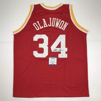 Autographed/Signed Hakeem Olajuwon Houston Red Basketball Jersey Beckett COA - Image 1 of 4