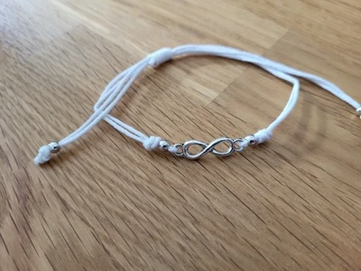 weißes Armband mit silbernem Anhänger Infinity größenverstellbar von Accessorize - Bild 1 von 2