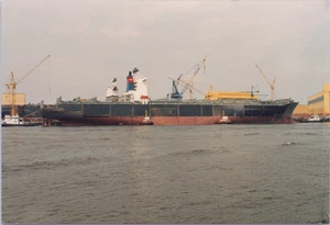 Foto Abzug : großes Containerschiff am Kai mit Schleppern - Bild 1 von 2