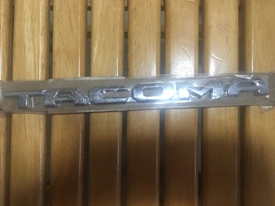 Placa de identificación cromada 75428-04010 emblema puerta izquierda Toyota Tacoma 2016-24 OEM 75428-04010 Foto 1 de 2