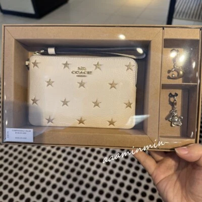 🎄Muñequera Coach con cremallera en esquina en caja con estampado de estrellas y dijes CX174 NUEVA CON ETIQUETAS VENTA AL POR MENOR: $148🎄 Foto 1 de 4