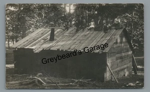 RPPC alter baufälliger Schuppen mit Familie posiert auf Dach Vintage Echtfoto Postkarte - Bild 1 von 2