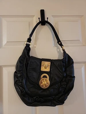 Bolso de mano Steven By Steven Madden de cuero negro con herrajes dorados llave en mano  Foto 1 de 4