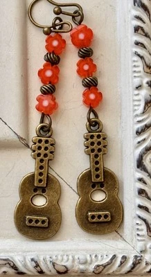 Ukelele de bronce con pendientes Lei de cuentas de flor naranja. Hawaii. Aloha Foto 1 de 3