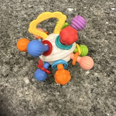 Juguete mordedor de bebé Nuby con bola giratoria texturizada con sonajero colorido Foto 1 de 4
