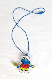 1982 SMURFS NECKLACE - SMURF PLAYING TENNIS - WITH PULL STRING ACTION RAQUET - Picture 1 of 5