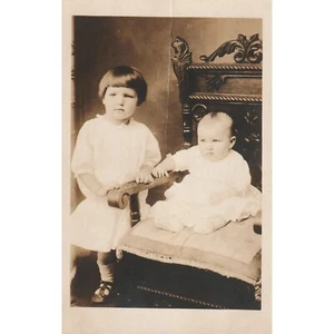 Postal con foto real RPPC bebé en silla niño pequeño de pie sin publicar LEER - Imagen 1 de 2