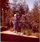 Old Found Photo - 60s 70s - Woman In Dress Stands Beside Blooming Flower Bush
