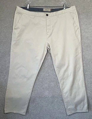 Next Pantalones chinos rectos elásticos para hombre color crema botón mosca talla W44” L29” Foto 1 de 4