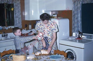 Orig Dia 50er Jahre Candid Mama Sohn Küche Schneiden Brot im Blumen Hausmantel 036N - Bild 1 von 1