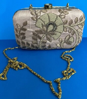 Bolso de mano Aesha con correa de cadena tono dorado.  Tela bordada rosa y dorada. Foto 1 de 4