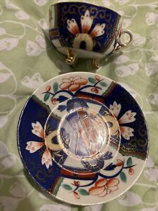 Vintage porcelain three footed tea cup with saucer